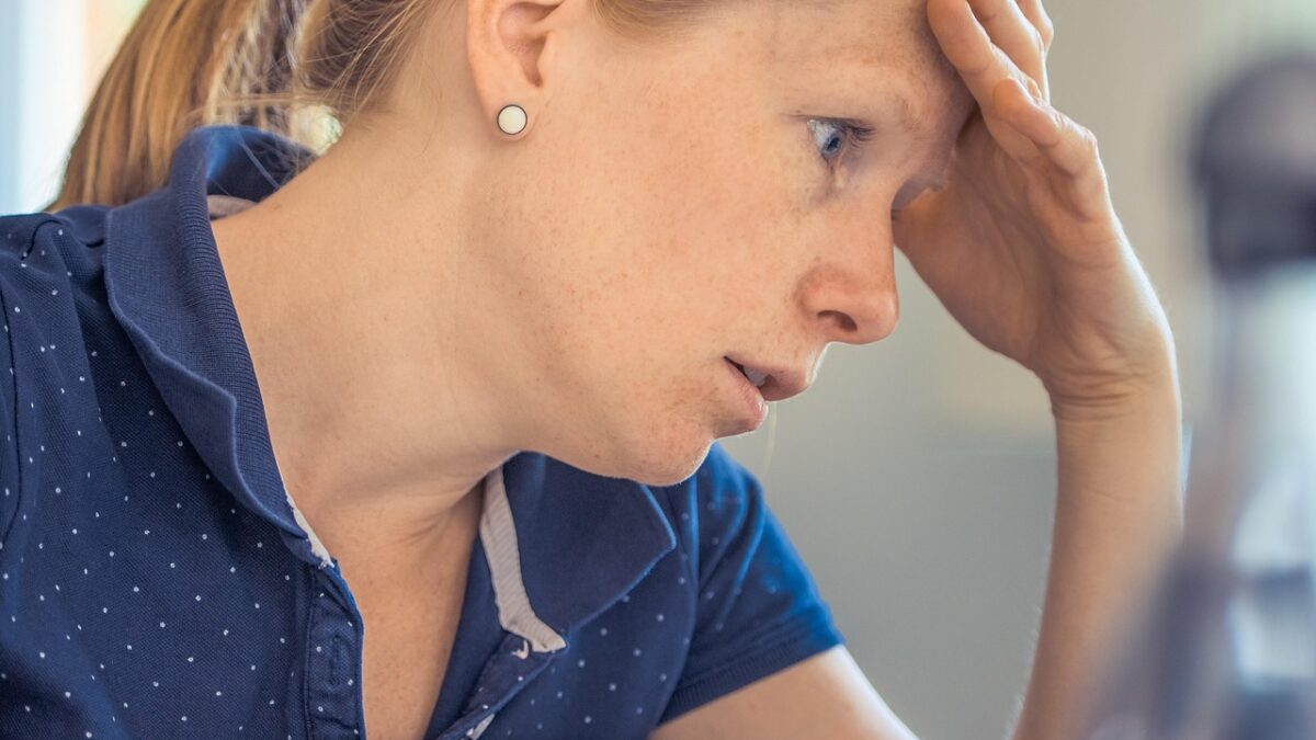 woman looking worried with hand on head