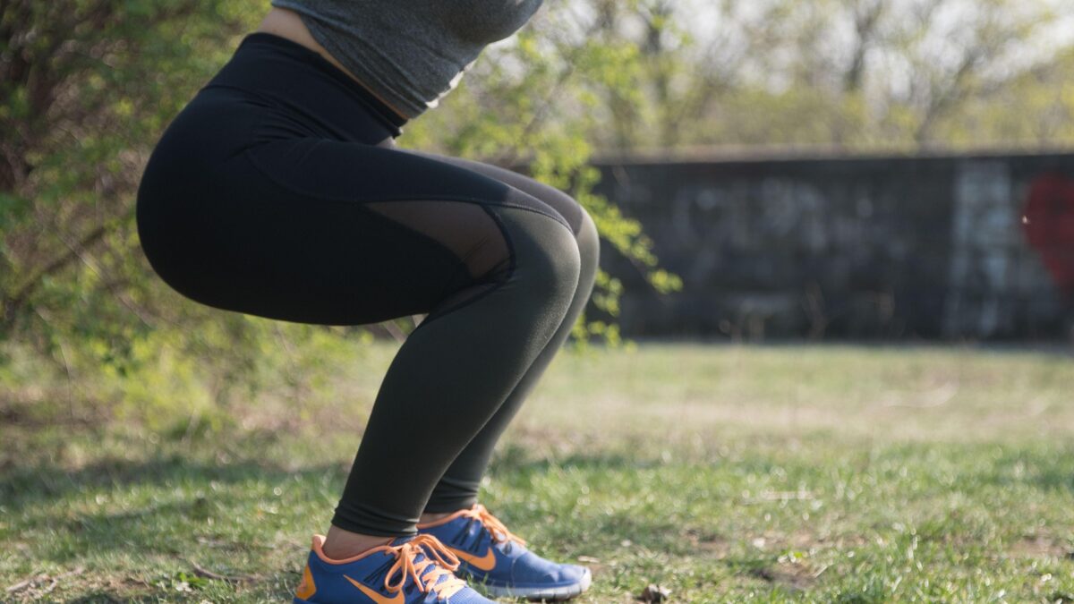 woman legs doing a squat in a park