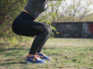 woman legs doing a squat in a park